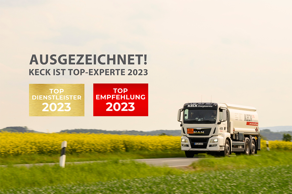 Weißer KECK-Tanklastwagen fährt auf einer Landstraße an einem gelben Rapsfeld vorbei; links große Beschriftung „AUSGEZEICHNET! KECK IST TOP-EXPERTE 2023“ und zwei Auszeichnungsabzeichen („Top Dienstleister 2023“ in Gold, „Top Empfehlung 2023“ in Rot).